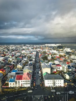 从戏剧性的多云天空鸟瞰，雷克雅未克色彩缤纷的建筑物和道路尽收眼底