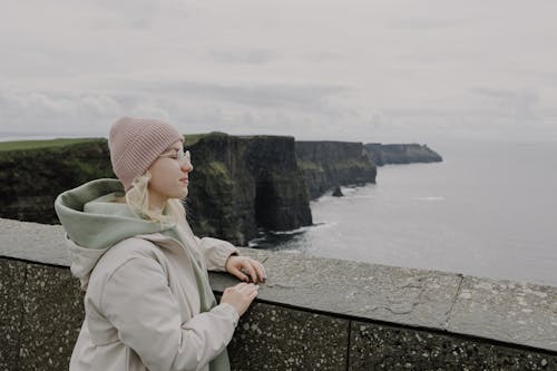 A woman in a beanie looking out over the ocean