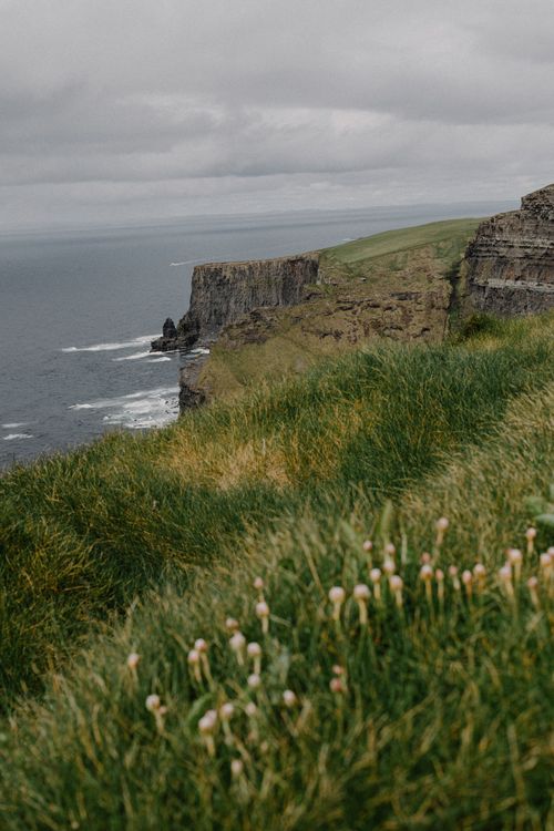 Free Scenic photograph of the iconic Cliffs of Moher with lush grass and the Atlantic Ocean. Stock Photo