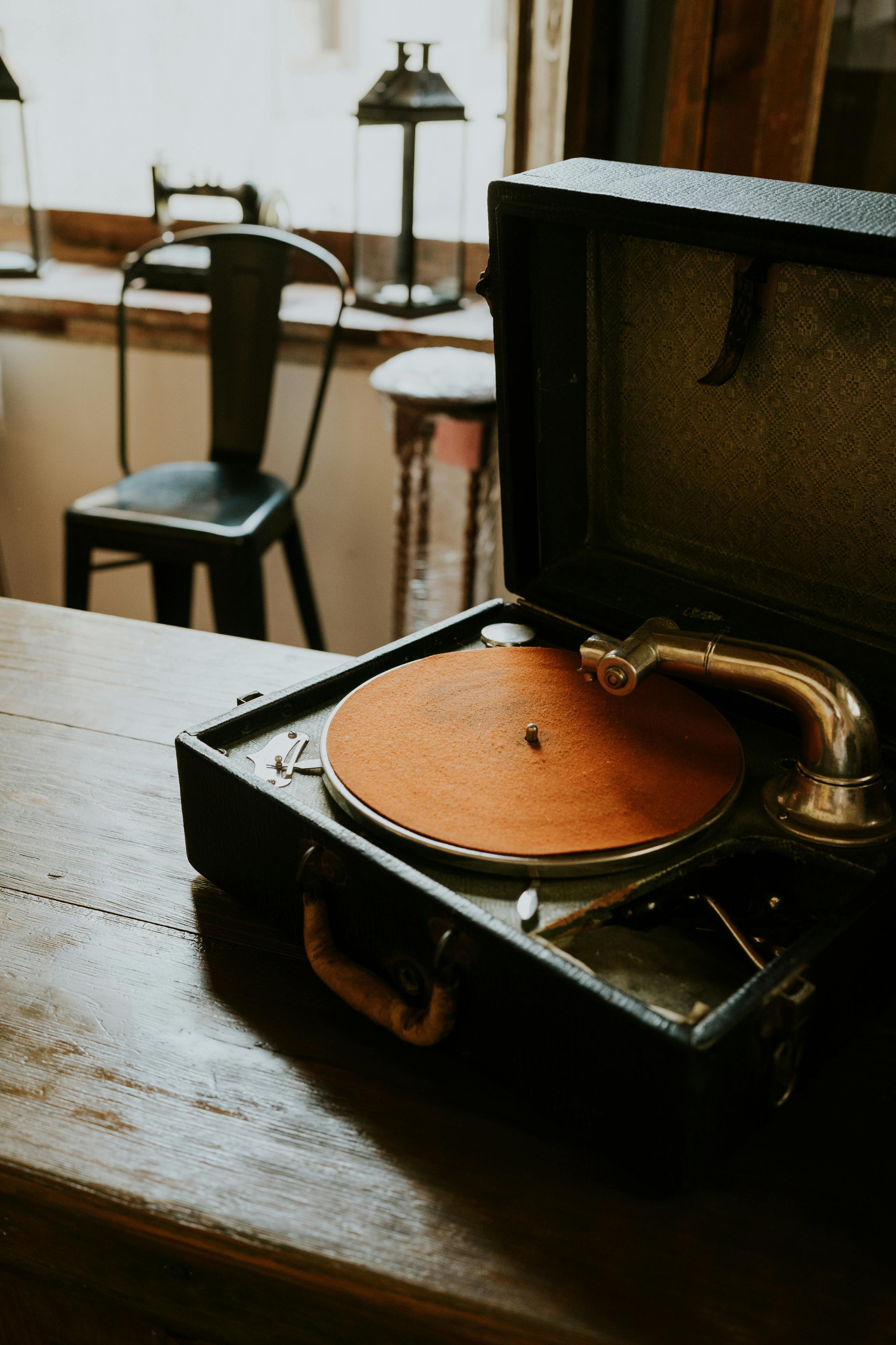 Retro gramophone with vinyl on a wooden table in a cozy, warm-lit indoor setting.