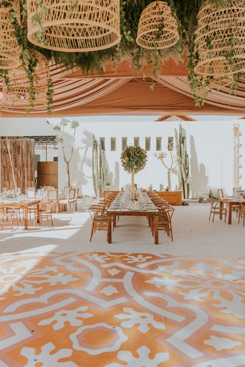 A wedding reception with a large table and hanging plants