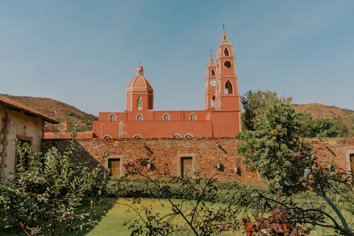 A red church in the middle of a green field