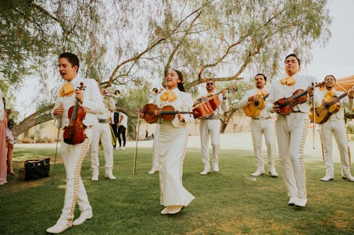 A mariachi band playing in the grass at a wedding