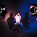 在一间灯光和阴影极具戏剧性的工作室里，一位时尚男士正在拍摄时尚照片