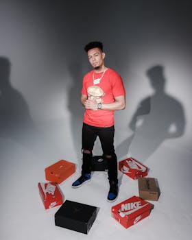 一名时尚男子穿着红色衬衫，在工作室里拿着盒子摆姿势