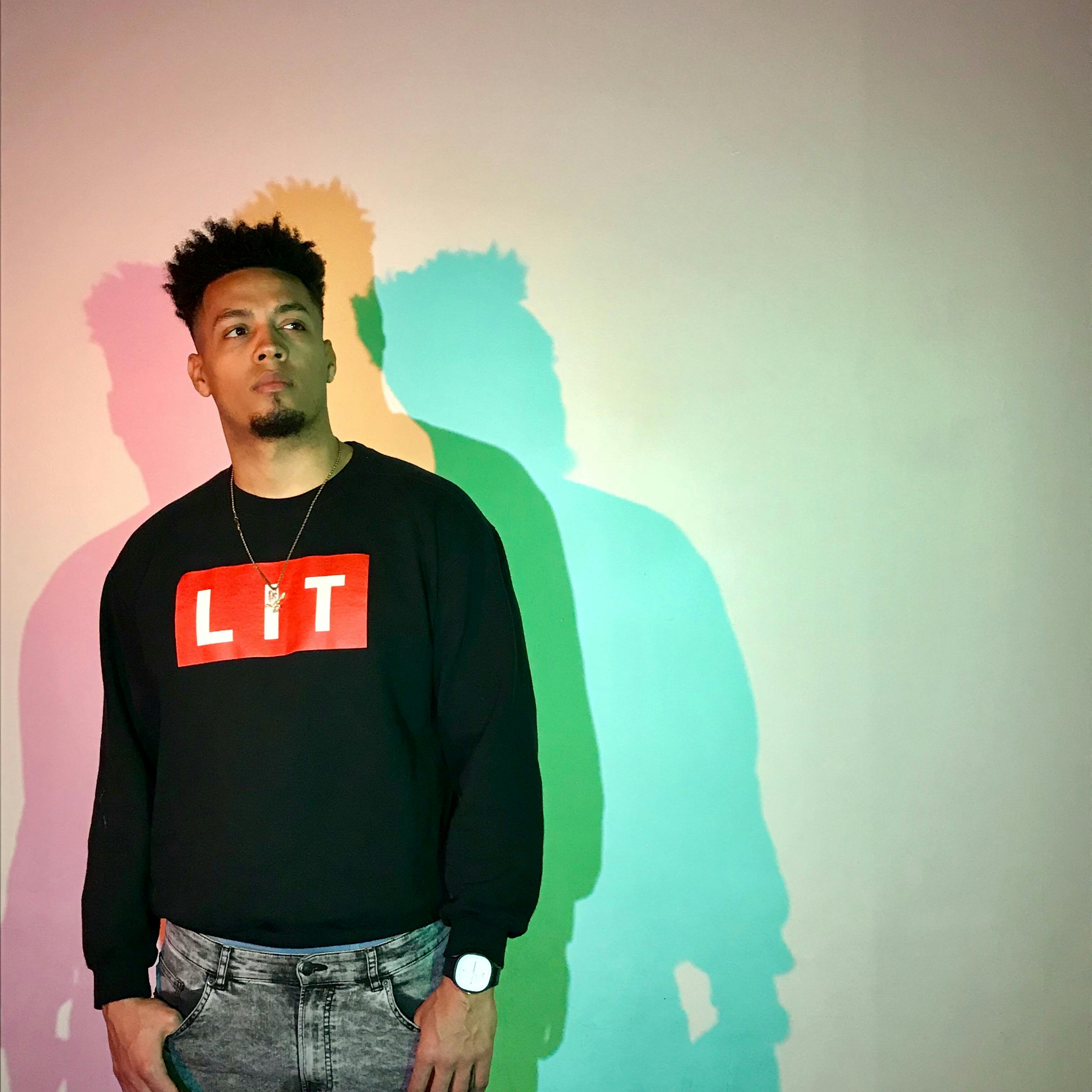 man in black lit shirt standing beside wall