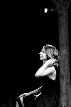 一位快乐的女子在户外树旁摆拍黑白肖像