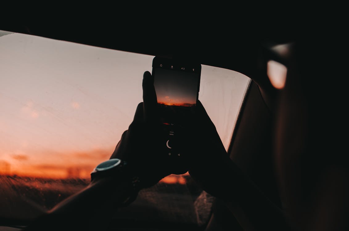 Free Person Using Smartphone during Golden Hour Stock Photo