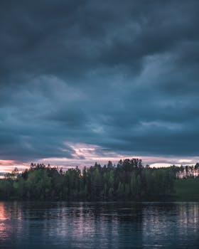 挪威索伦桑德，傍晚多云天空下，湖泊与森林呈现出一片宁静的景色
