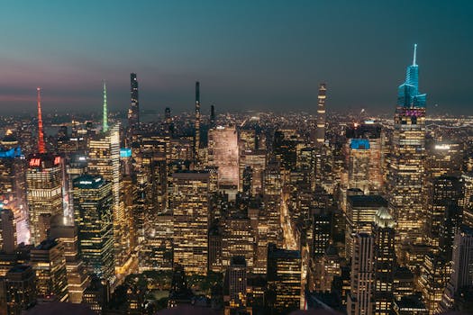 Captivating aerial view of New York City skyline at night showcasing illuminated skyscrapers and urban landscape.