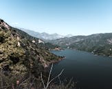 蔚蓝的天空下，高山水库的鸟瞰图令人惊叹，四周环绕着郁郁葱葱的绿植