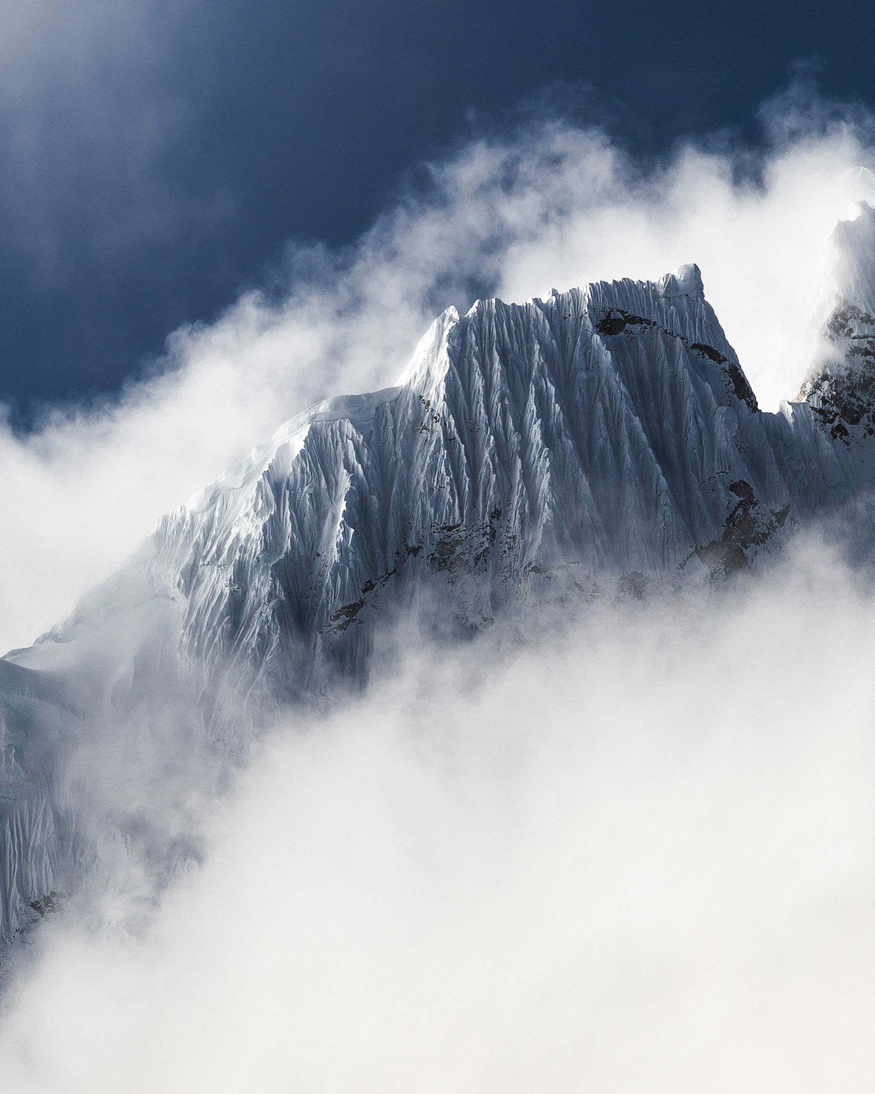 Cumbre nevada entre nubes en pleno invierno