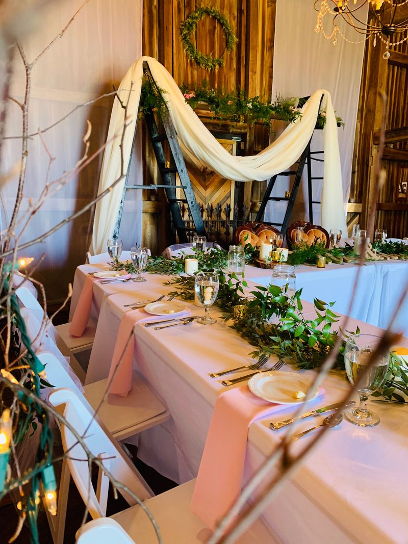 Elegant draped wedding reception hall with floral centerpieces
