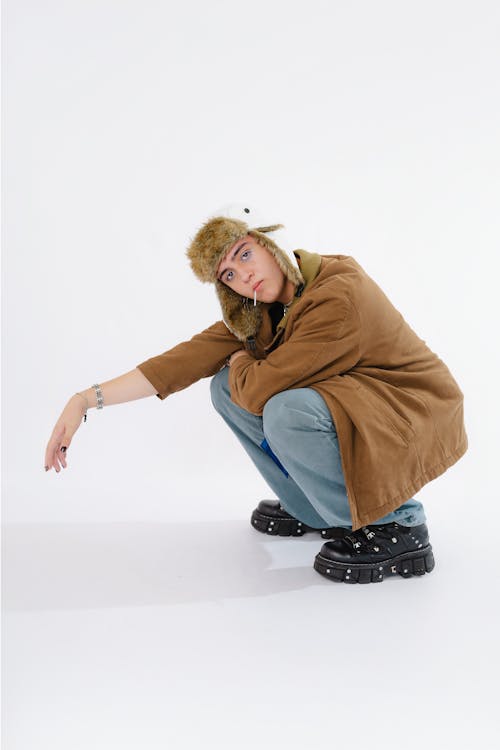 A woman in a brown coat crouches down