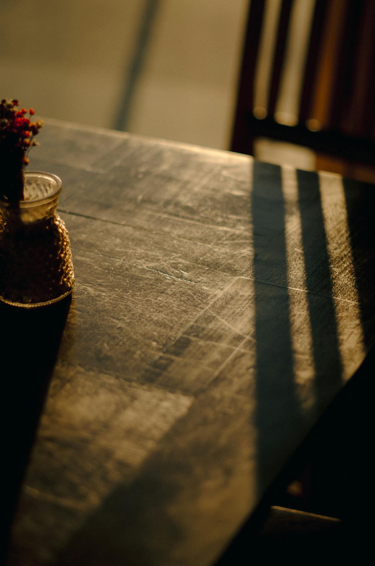 Tavolo in legno graffiato illuminato dalla luce calante del sole