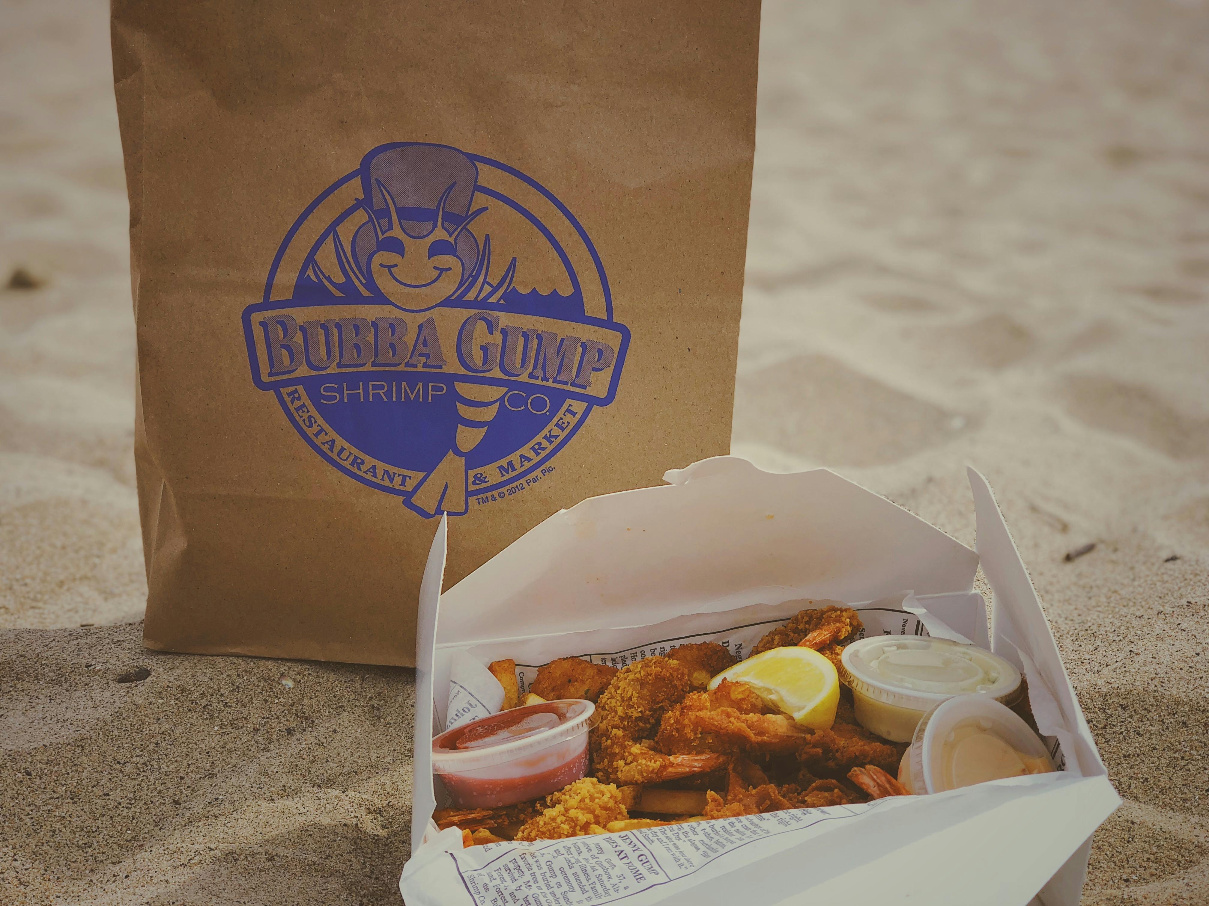Takeaway seafood meal from Bubba Gump Shrimp Co. enjoyed on a sandy beach in Los Angeles.