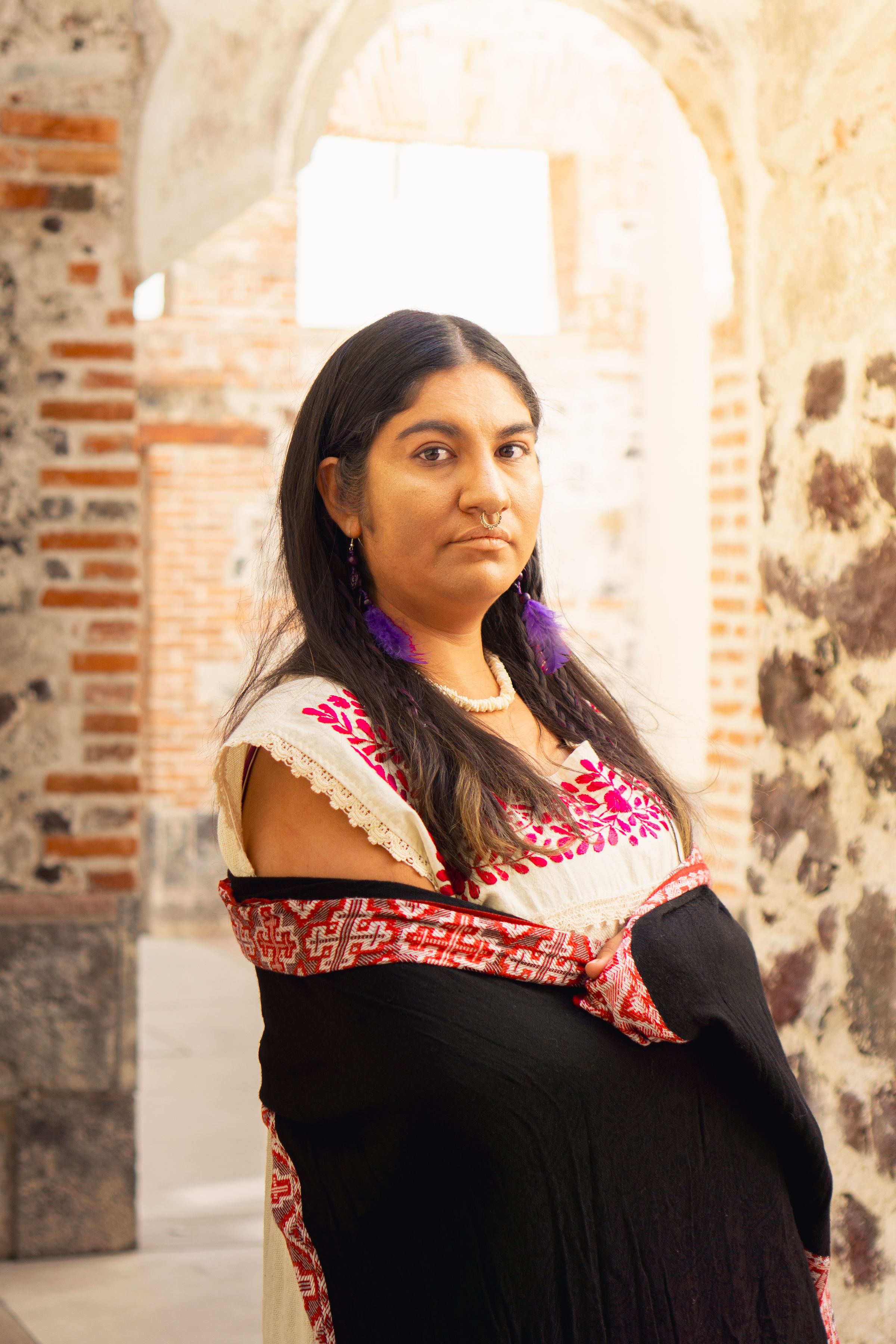 Portrait of a woman in traditional Mexican attire in an archway, showcasing rich cultural heritage.