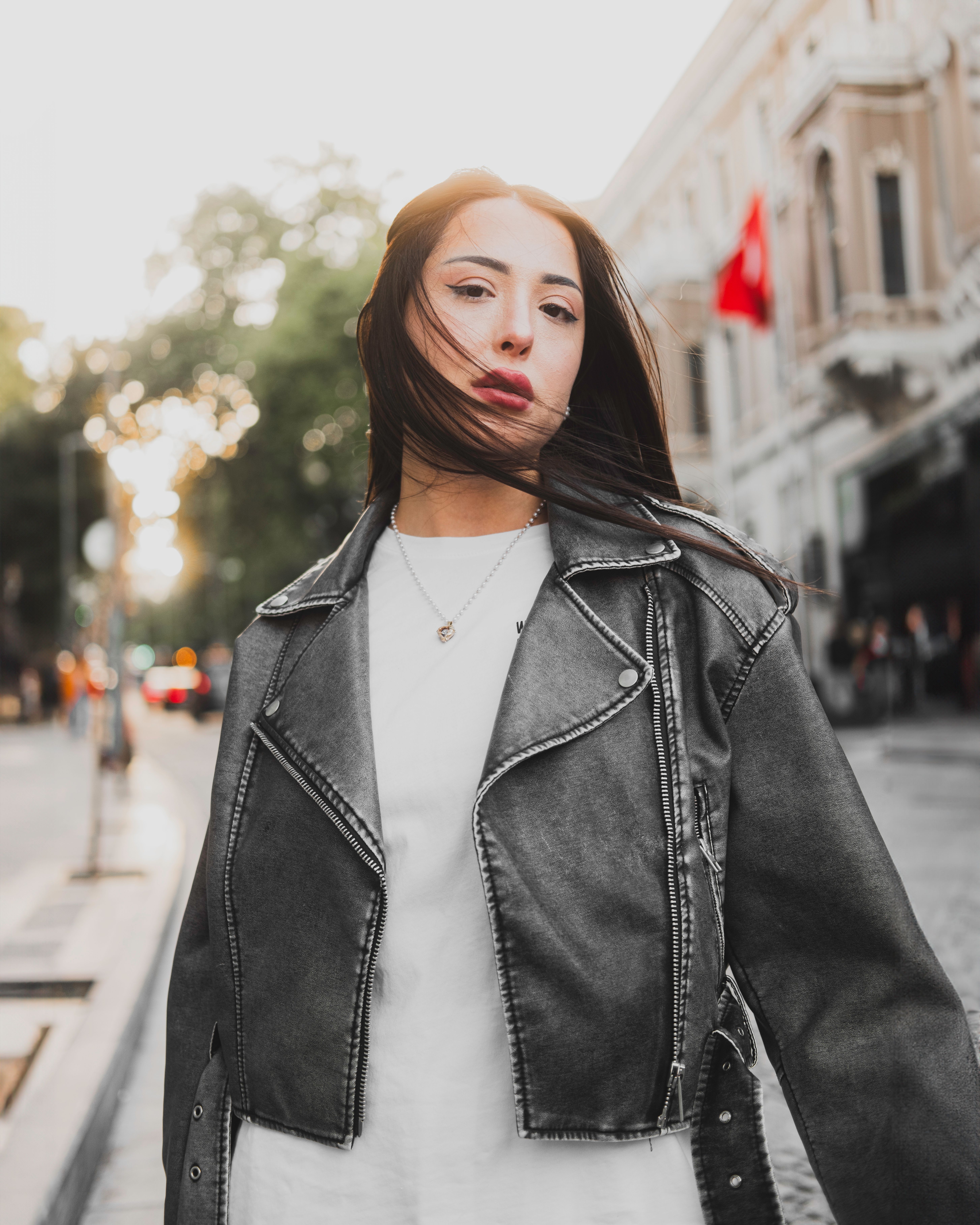 Young Brunette in a Leather Jacket Posing on a Street · Free Stock Photo
