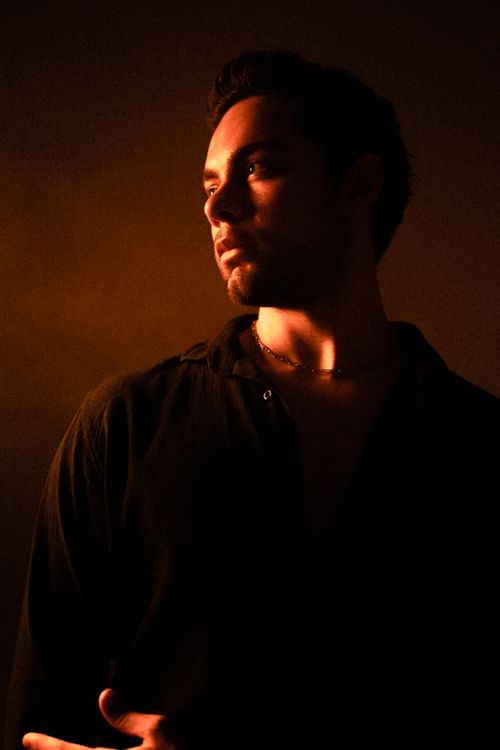 Free A pensive male model in dramatic red lighting, creating a serene and serious atmosphere. Stock Photo