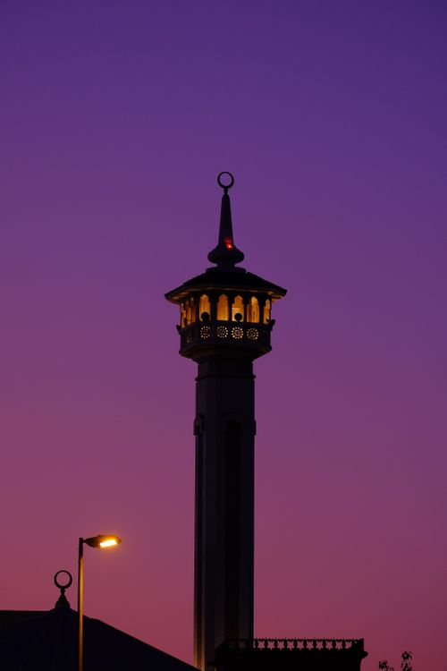 Free Silhouette of a minaret against a vibrant pink and purple sunset sky, capturing a serene evening. Stock Photo