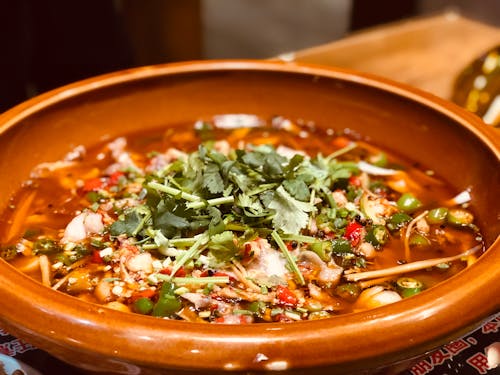 Green Basil Topped Dish in Brown Bowl