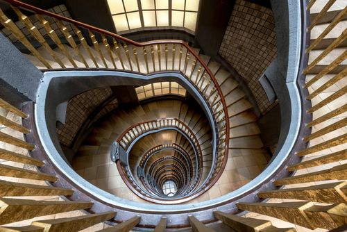 Free Top-down view of a spiral staircase with golden railings in Hamburg, Germany. Stock Photo