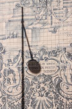 Captivating azulejos tiles mural in Porto, featuring shadows from a nearby lamp.