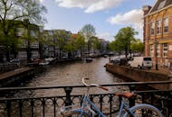 阳光明媚的日子里，阿姆斯特丹运河风景如画，自行车、船只和经典建筑点缀其间