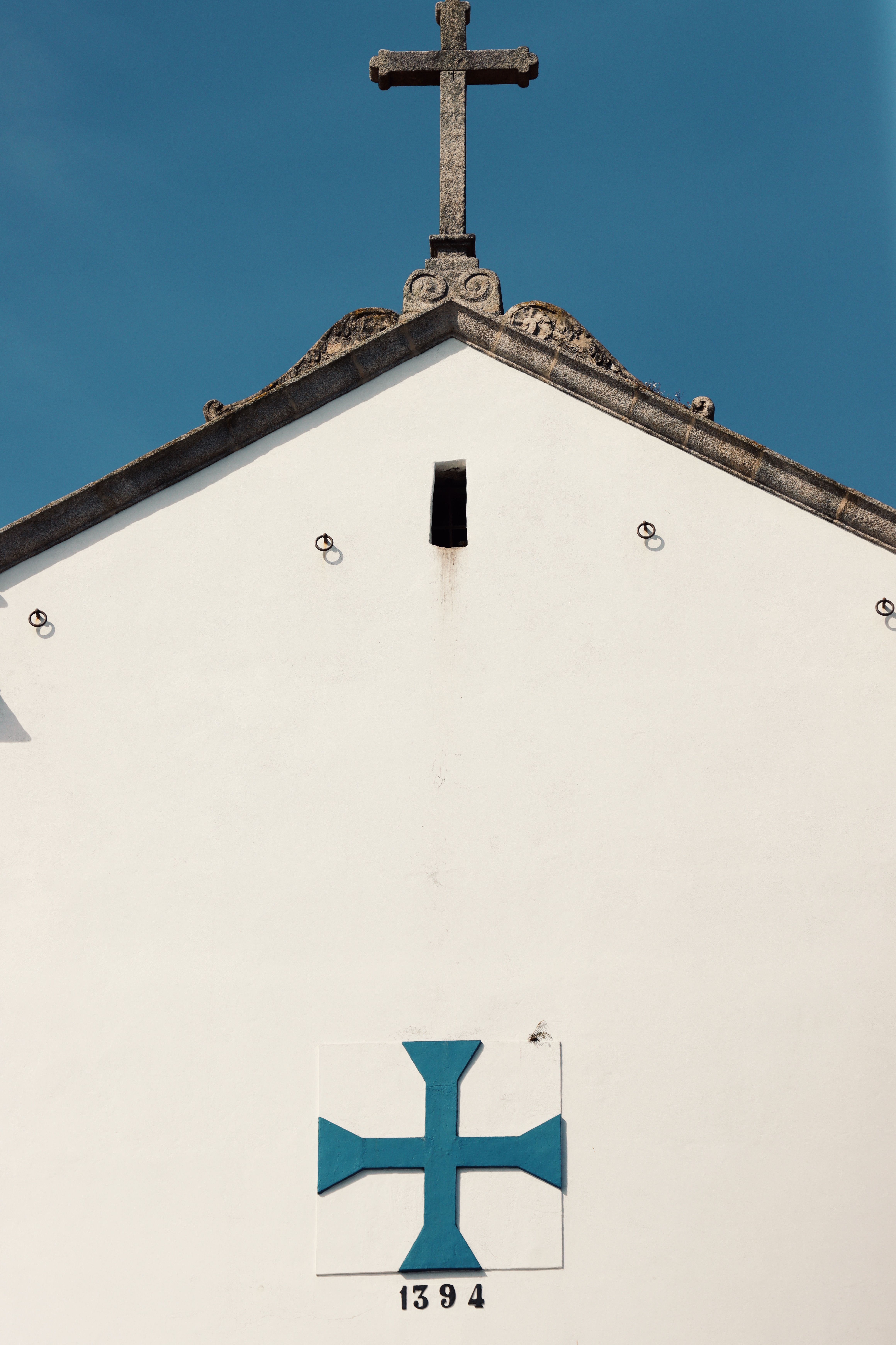 A minimalist view of a church facade with a cross in Porto, Portugal.