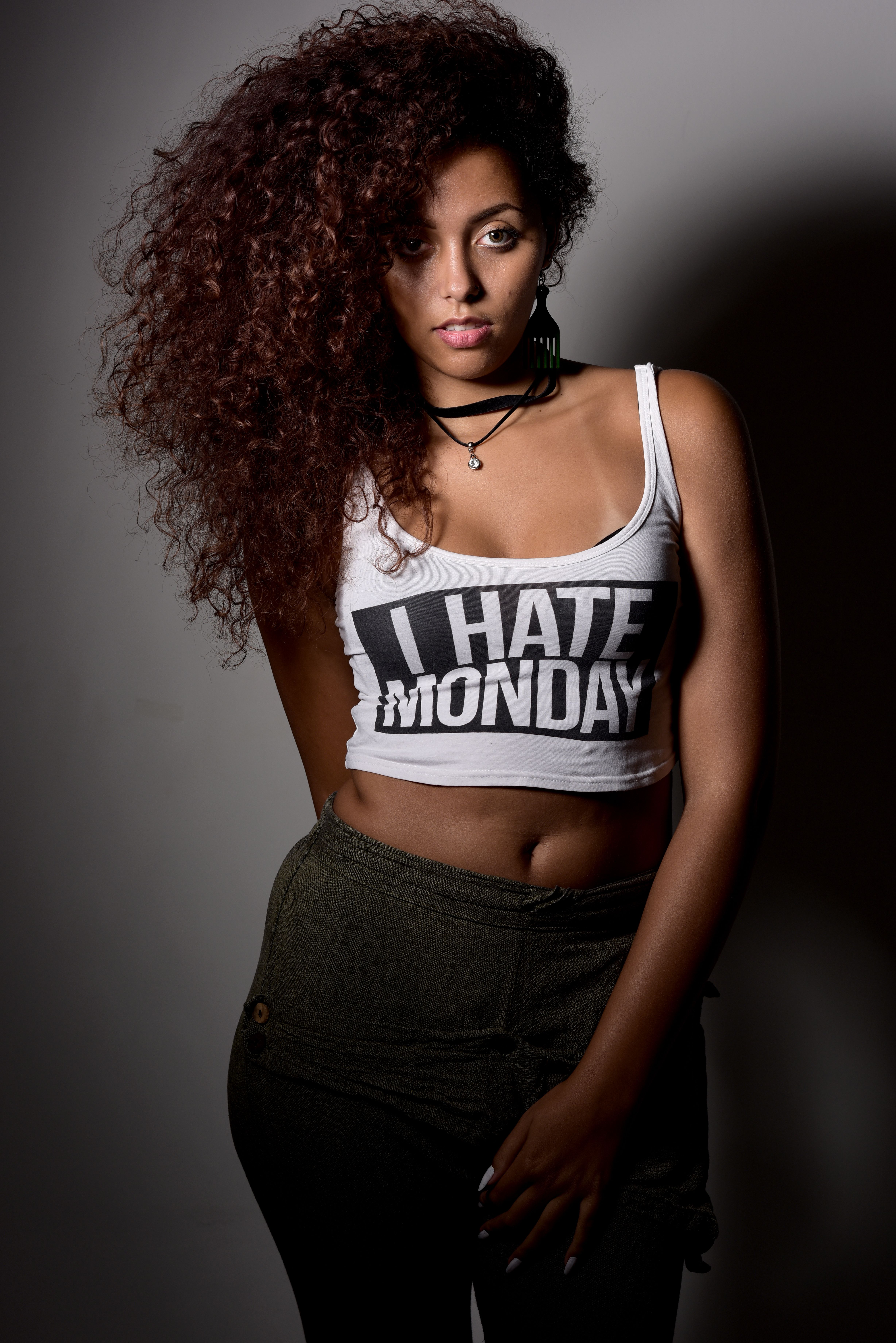 Fashion portrait of a woman with curly hair wearing an 'I Hate Monday' tank top.