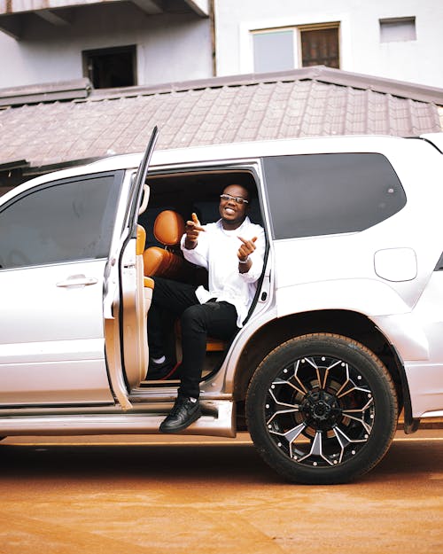 A man sitting in the back of a white suv