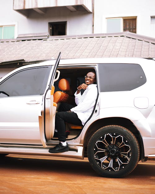 A man sitting in the back of a white suv