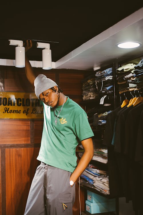 A man in a green shirt standing in a closet