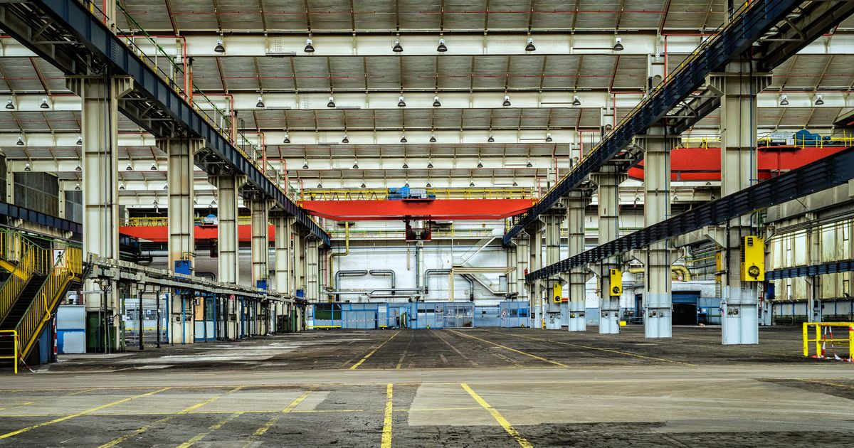 Große leere Industrie- und Logistikhalle mit Fahrwegmarkierungen, Grundlage für die Kalkulation der Hallenreinigung
