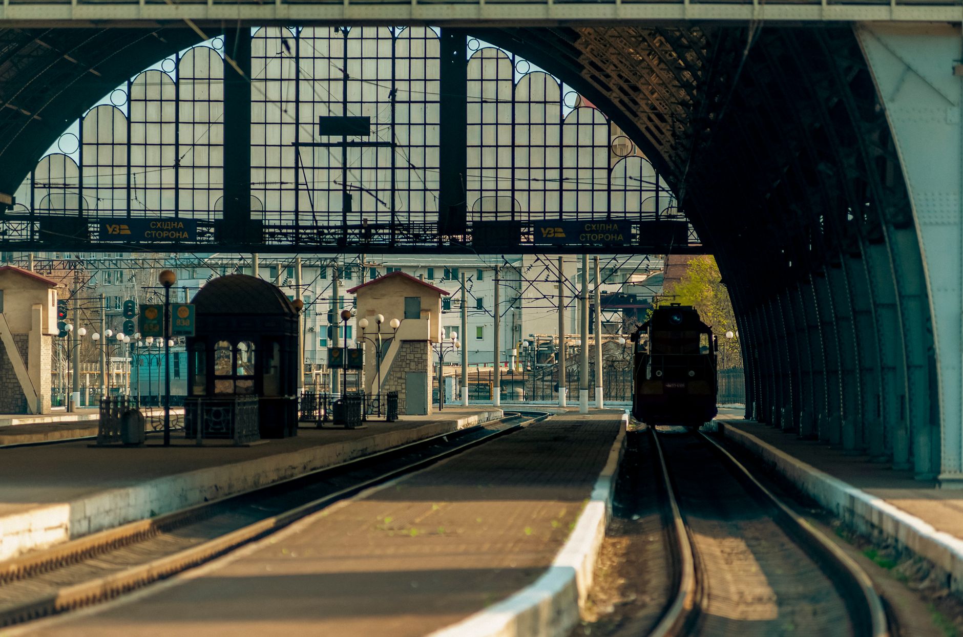 Interior view of Lviv railway station with a train approaching the platform. Captures urban travel atmosphere.