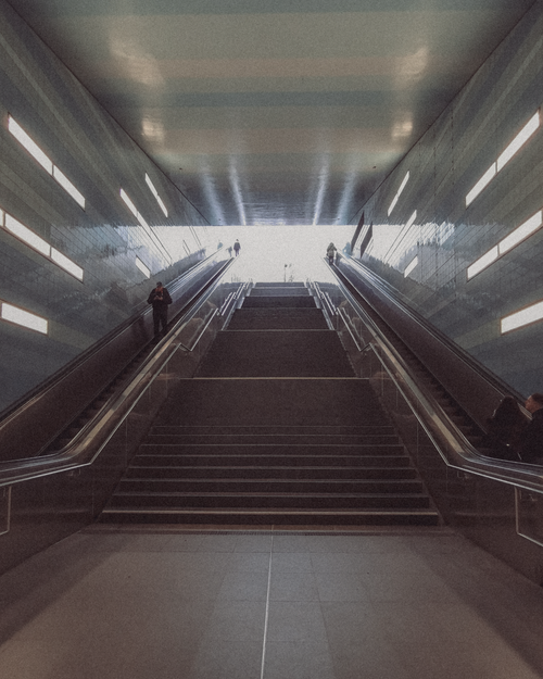 Free A dynamic view of an urban subway station with escalators leading to the surface. Stock Photo
