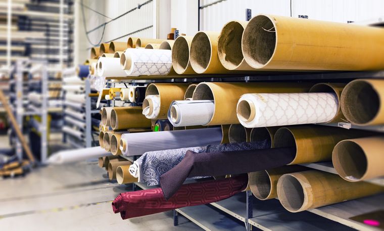 Bolts of cloth racked in the order store — photo by Pixabay on Pexels