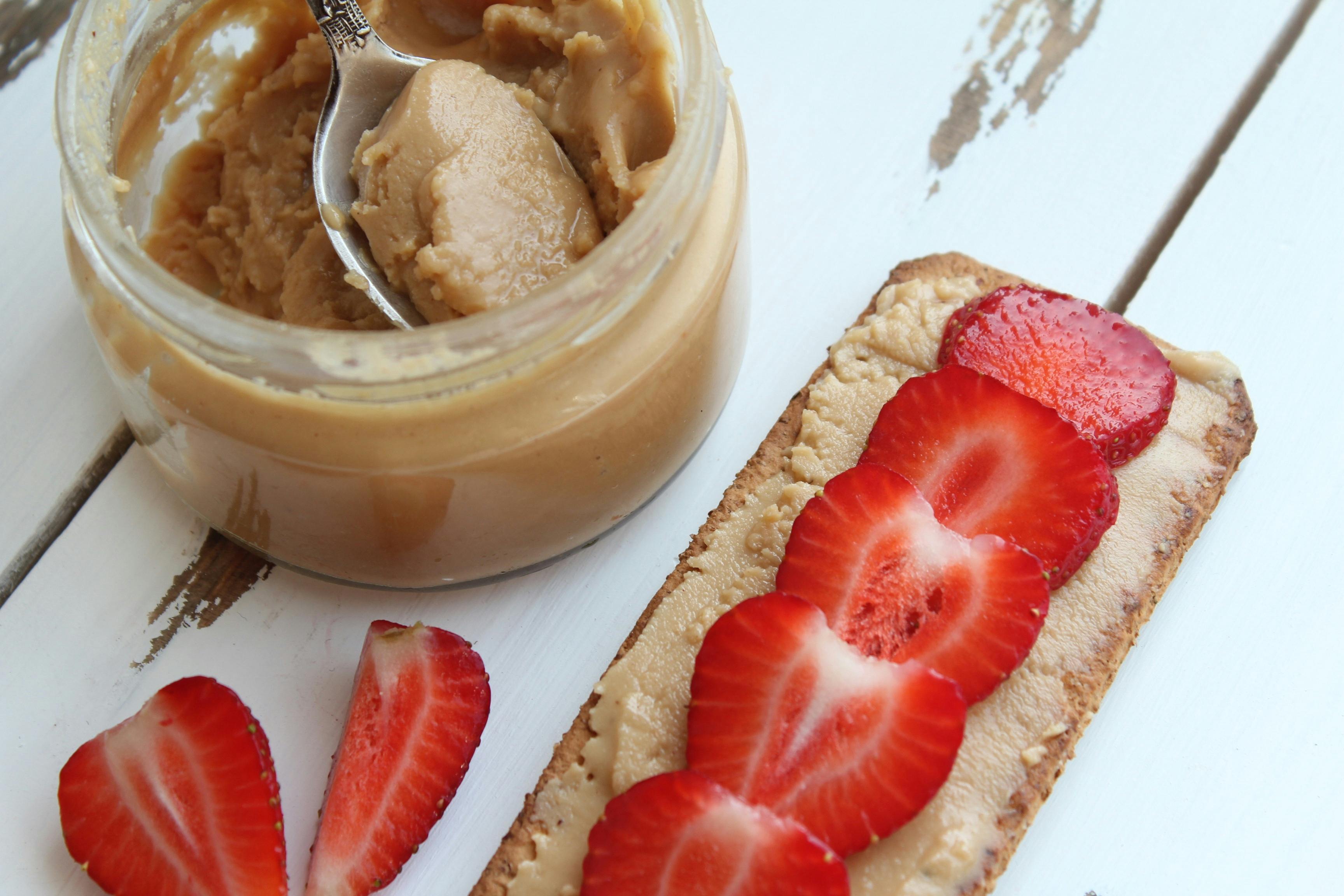 Peanut Butter Besides Sliced Strawberries on Baked Pastry