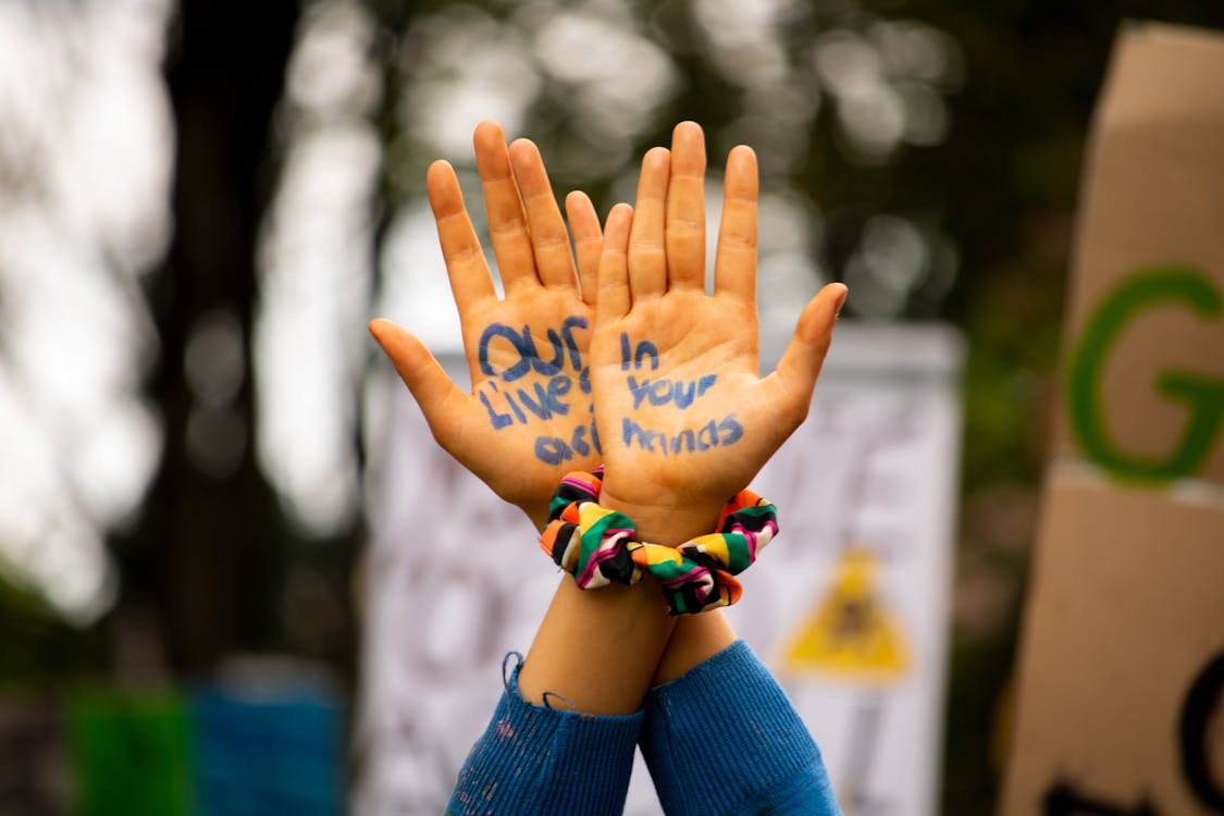 Person Wearing Blue Long-sleeved Shirt While Raising Hands