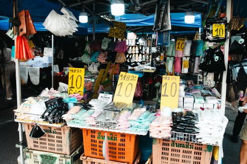 Free Colorful street market with clothing stalls and sale signs, vibrant and bustling. Stock Photo
