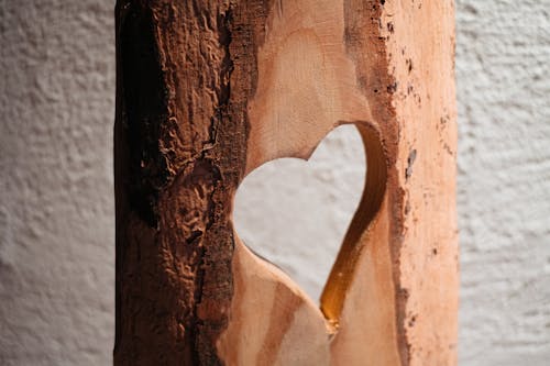 A heart shaped wooden sculpture with a hole in it