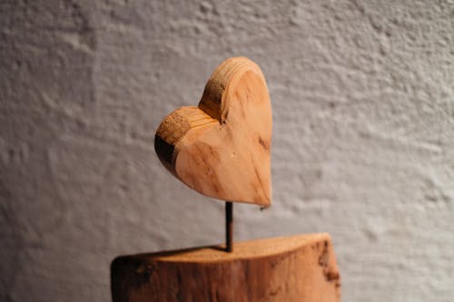 A wooden heart shaped piece of wood on a stand