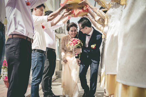 Bride and Groom Walking Between People Standing