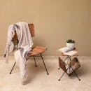 舒适的阅读角落里，柳条椅、毯子和小桌子一应俱全，上面还摆着书籍和植物