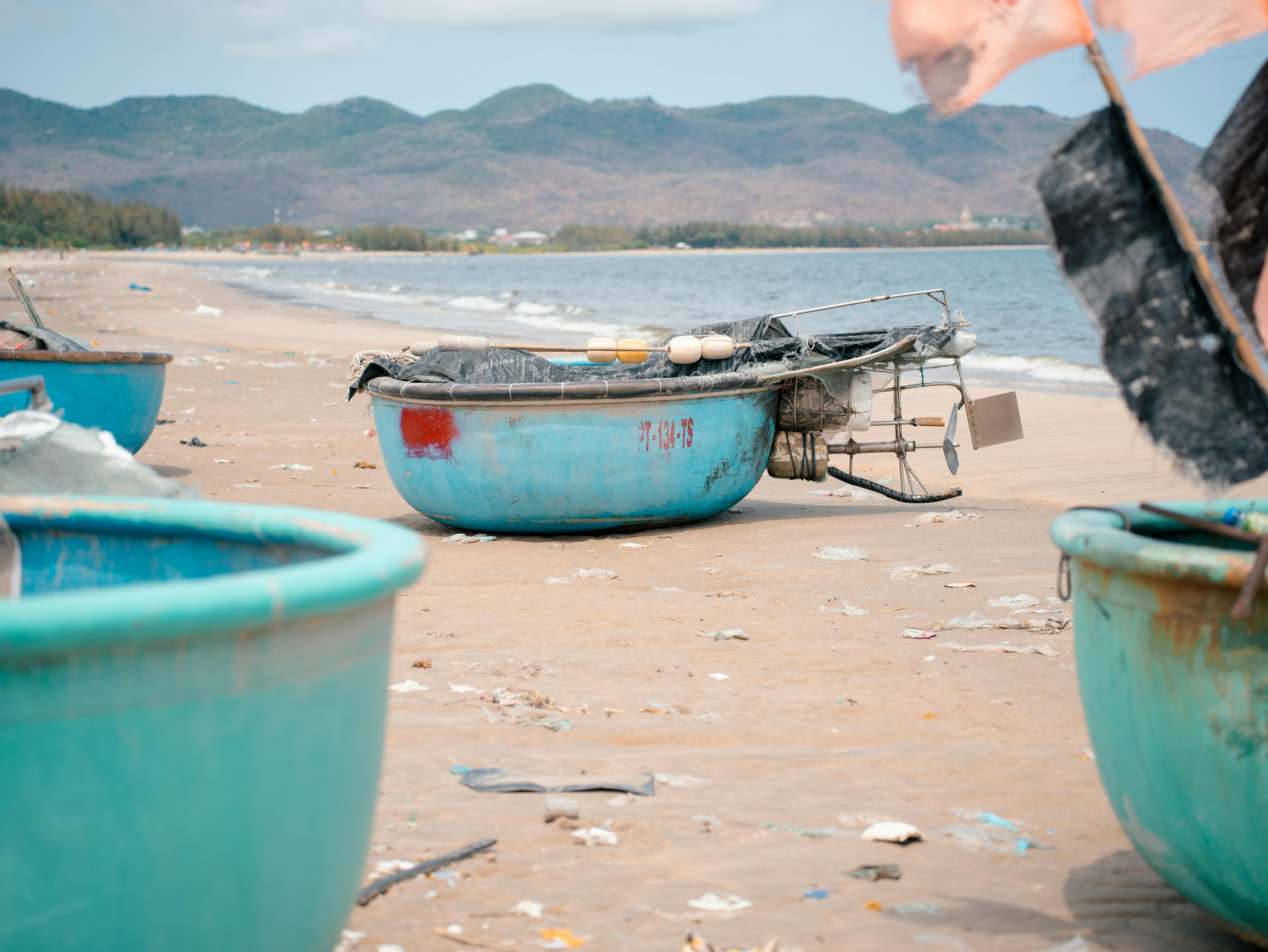 Scenic view of traditional basket boats on a Vietnamese beach with mountains in the background.
