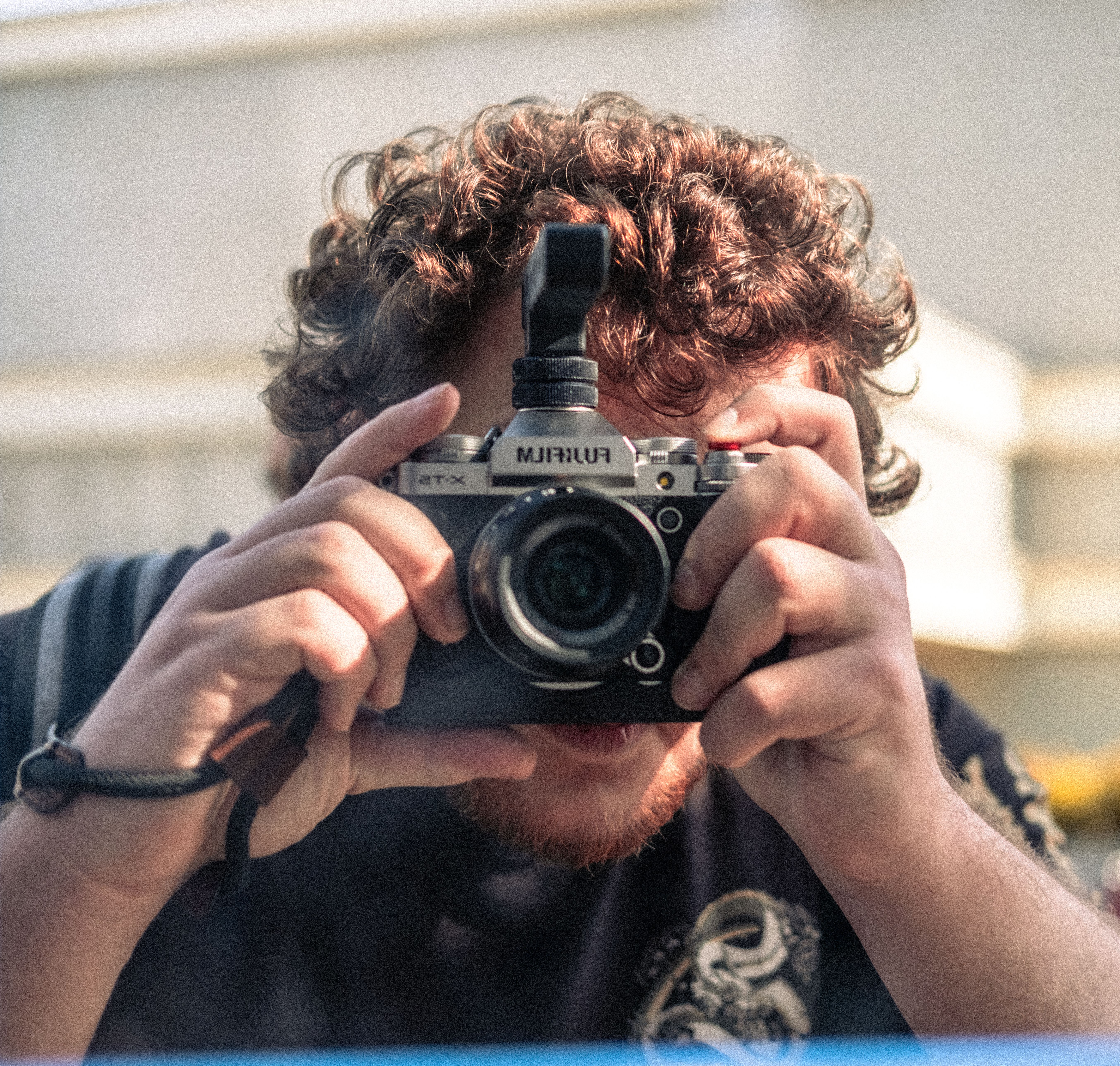 A close-up portrait of a man taking a picture with a vintage camera.