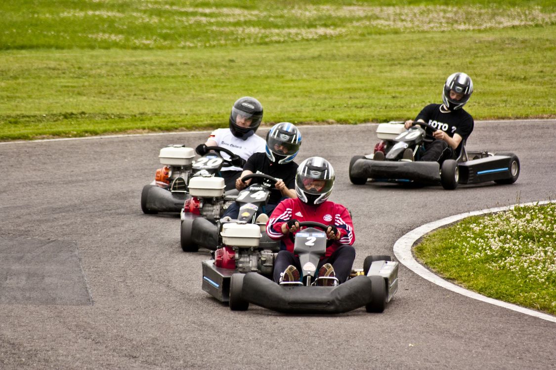 Karting sur circuit - sensations de pilotage électrique Pilote en pleine course sur une piste de karting extérieure
