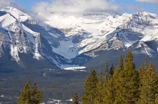 Breathtaking view of snow-covered Rocky Mountains with evergreen trees in winter.