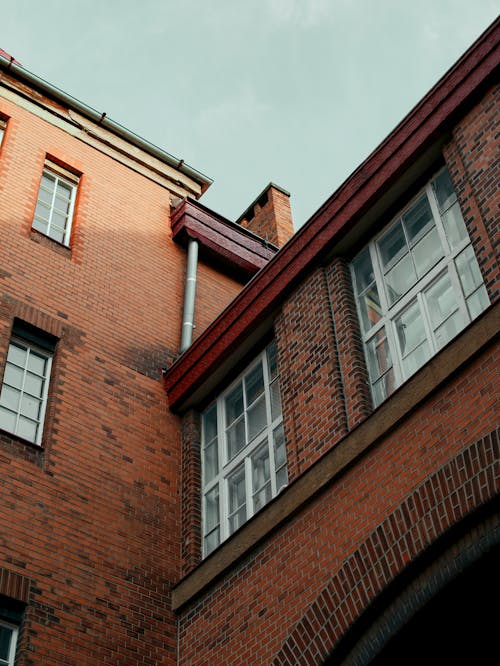 A red brick building with windows and a blue sky