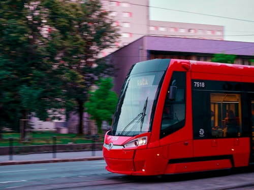 A red tram traveling down a street